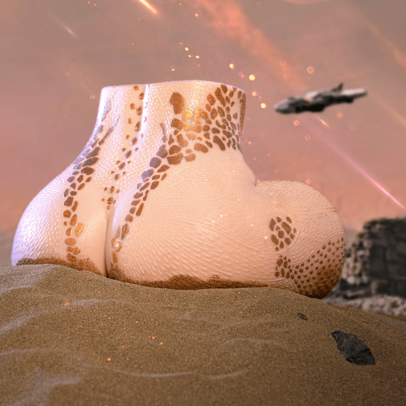 Realistic male masturbator with textured skin, gold speckles, and curved shape on sandy surface