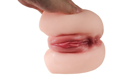 Hand holding realistic pink silicone male masturbator with detailed vaginal opening and textured inner walls