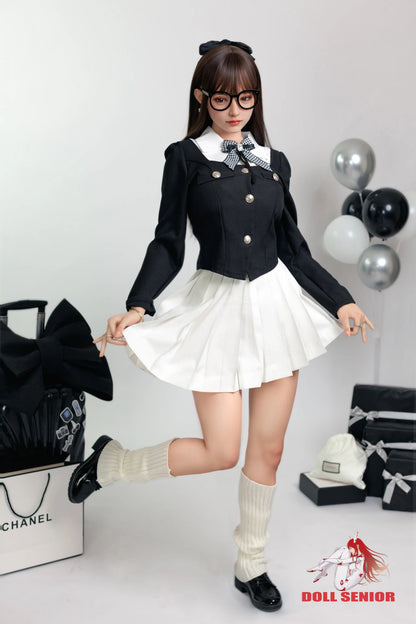Realistic female doll in black blazer, white pleated skirt, and glasses, posing with shopping bags and balloons.