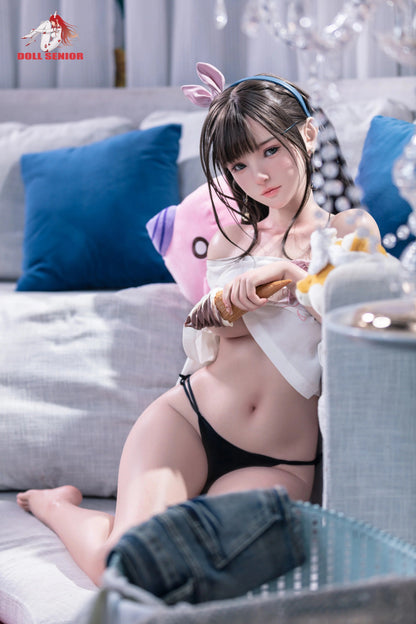 Realistic female doll with brown hair, pink bunny ears, holding ice cream, wearing black lingerie on gray couch