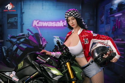 Realistic female figure in red racing jacket and checkered bandana, posing with Kawasaki motorcycle in garage setting.