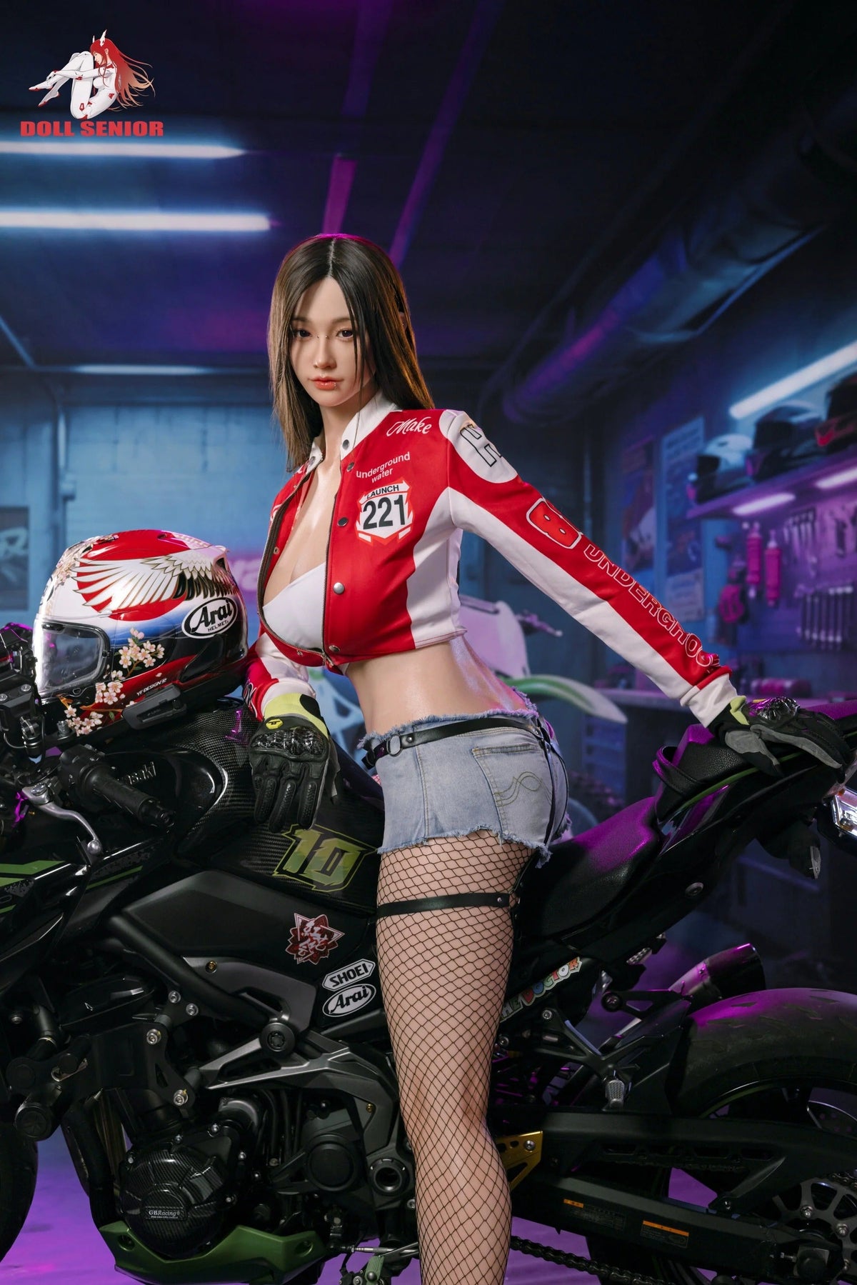 Realistic female doll in red racing jacket and denim shorts posing beside a black motorcycle in a neon-lit garage.