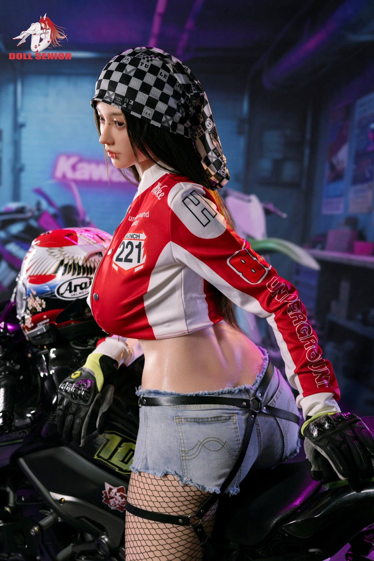 Realistic female doll in red racing jacket, denim shorts, and fishnet stockings, posed on a motorcycle with checkered bandana.