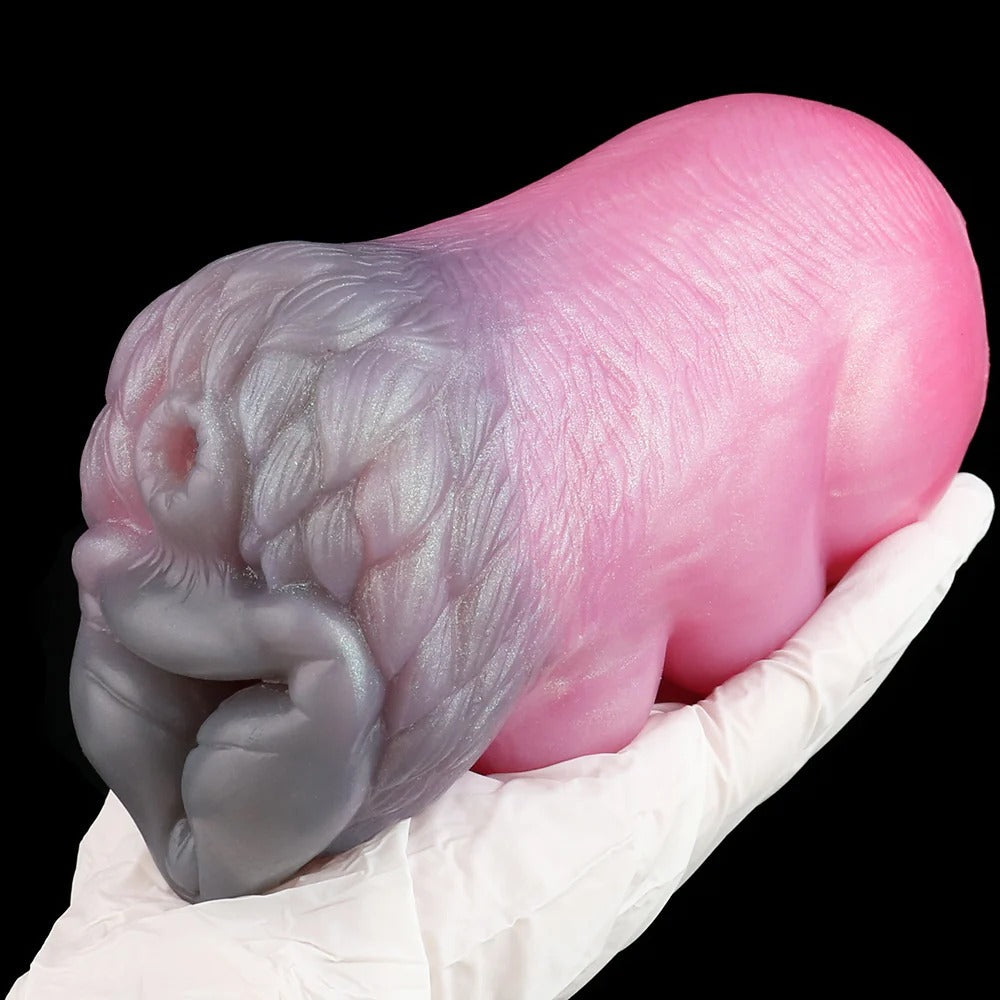Realistic pink and gray silicone male masturbator with detailed texture, held in gloved hand