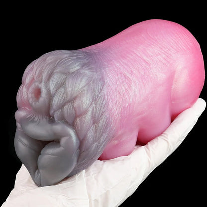 Realistic pink and gray silicone male masturbator with detailed texture, held in gloved hand
