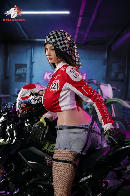 Realistic female figure in red racing jacket, denim shorts, and fishnet stockings, posing beside a motorcycle in a garage.