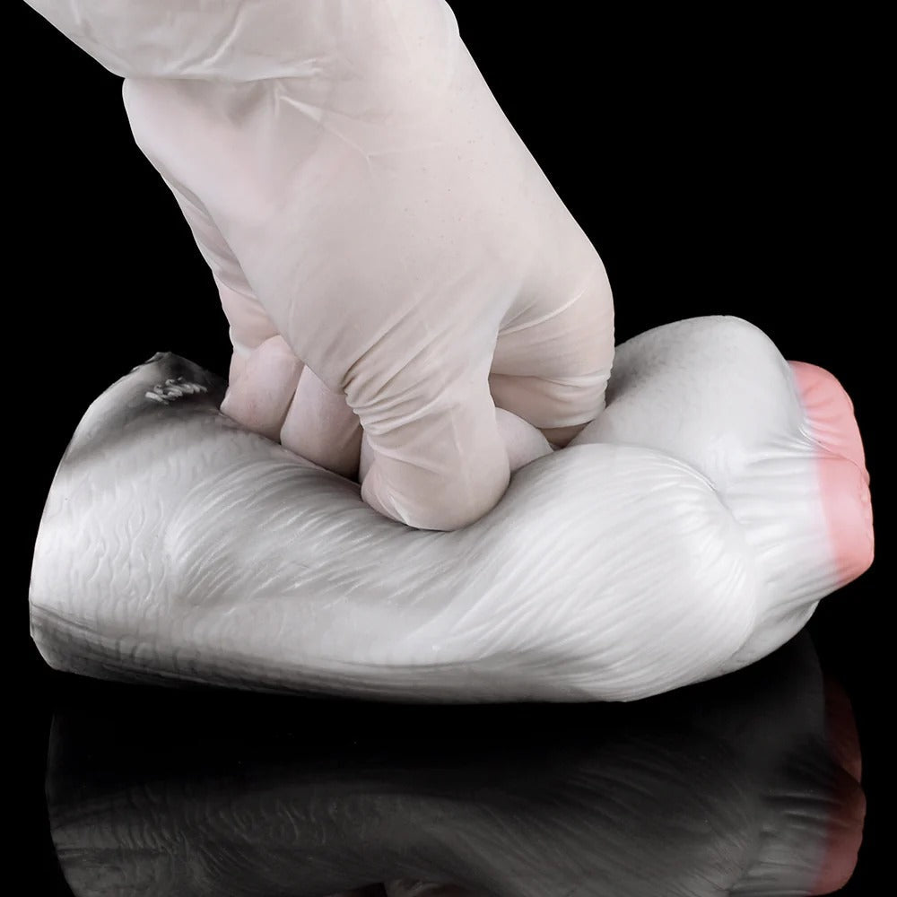 Realistic male masturbator with soft, textured skin and natural contours, shown being gently squeezed.