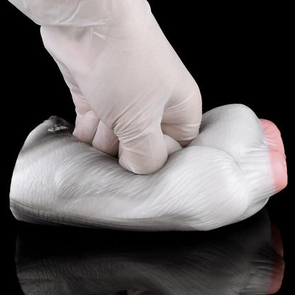 Realistic male masturbator with soft, textured skin and natural contours, shown being gently squeezed.