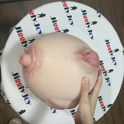 Realistic silicone male masturbator with detailed labia and natural skin texture, held gently in hand.