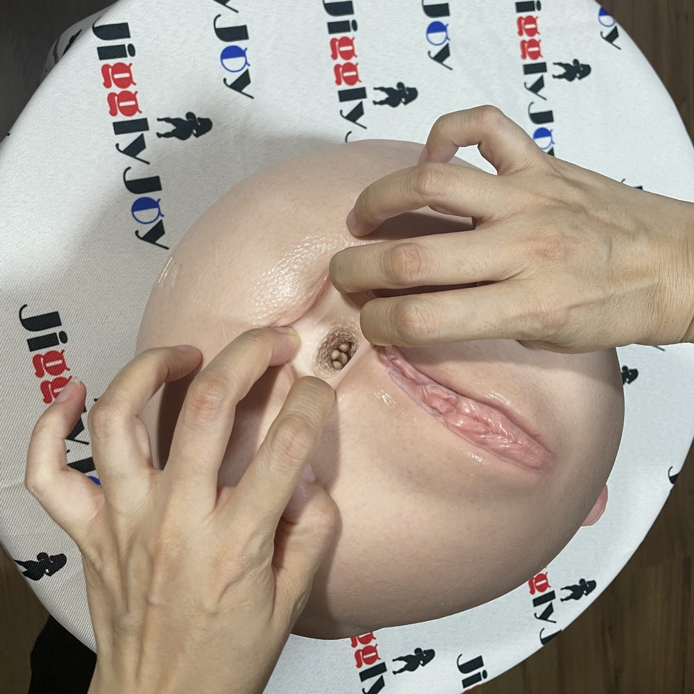 Realistic silicone male masturbator with detailed vaginal and anal openings, soft skin texture, natural pink tones