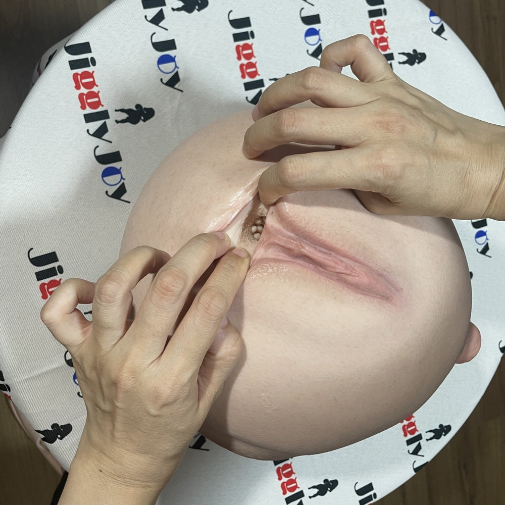 Realistic flesh-toned male masturbator with detailed labia and textured interior, shown with hands demonstrating use