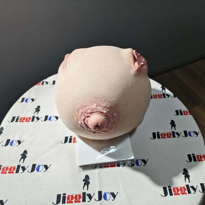 Realistic male masturbator with detailed labia and natural skin texture, displayed on branded packaging