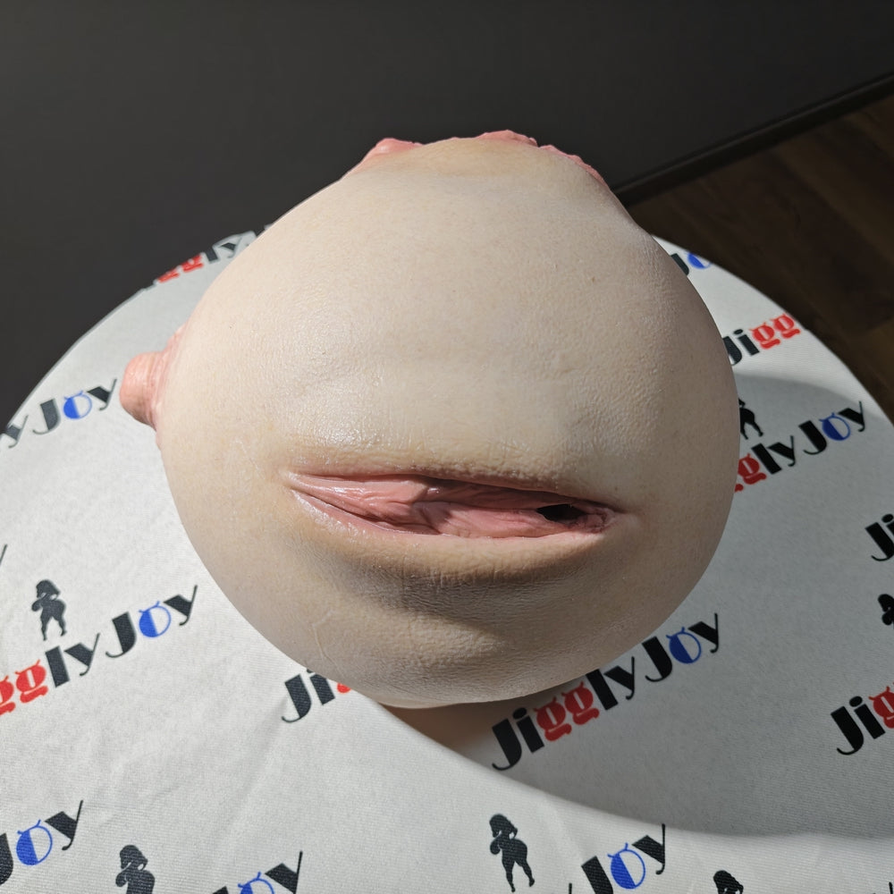 Realistic male masturbator with lifelike skin texture and natural pink labia detail on branded display