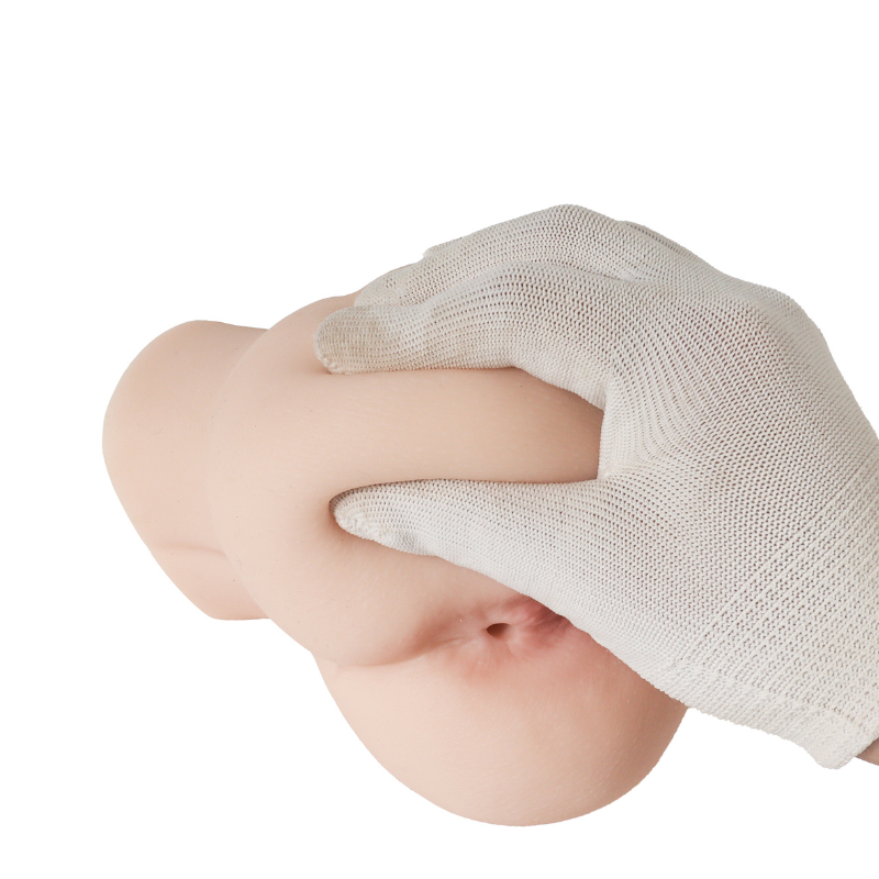 Realistic flesh-toned male masturbator with soft, textured surface, gently held by gloved hand