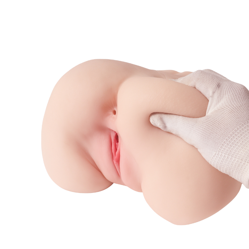 Realistic flesh-toned male masturbator with detailed labia and soft silicone texture, held by gloved hand